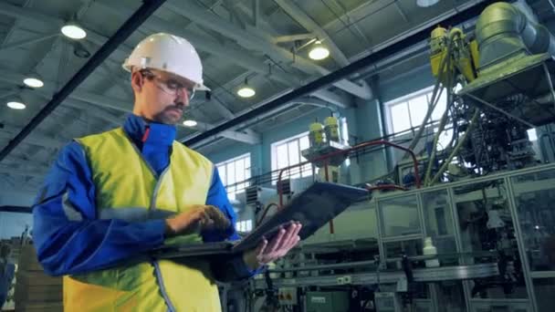 Ein Ingenieur tippt auf einem Laptop und arbeitet in einer speziellen Einrichtung. — Stockvideo