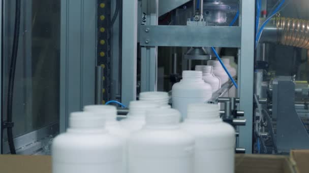 Travailleur d'usine prend des bouteilles en plastique d'un convoyeur, ligne automatisée . — Video