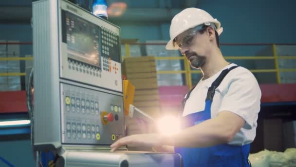 Mannelijke werknemer typen op een fabriek machine, moderne apparatuur. — Stockvideo