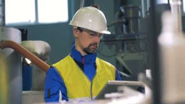 Bitki makineleri kontrol bir tablet ile çalışan erkek mühendisi.