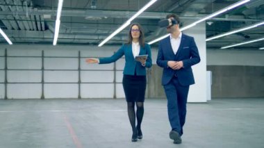 Emlakçı ve bir odada yürürken Vr gözlükle işadamı.