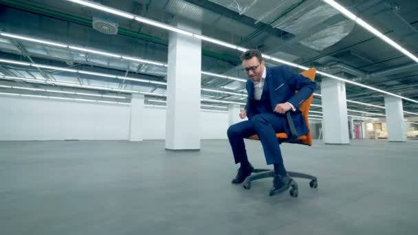 Mužské úředník na koni židle k psacímu stolu, baví. — Stock video