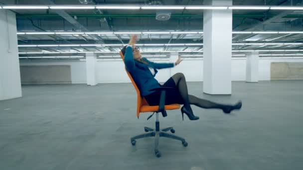 Une femme chevauchant une chaise sur roues, travailleur de bureau joyeux . — Video