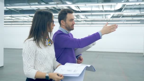 Gli ingegneri lavorano con il progetto mentre camminano in un edificio . — Video Stock