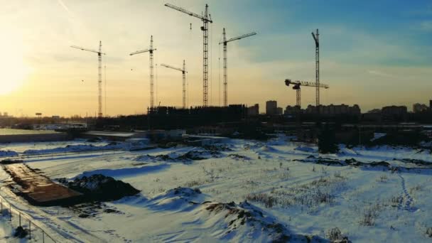 Many cranes on a construction site in winter. — Stock Video