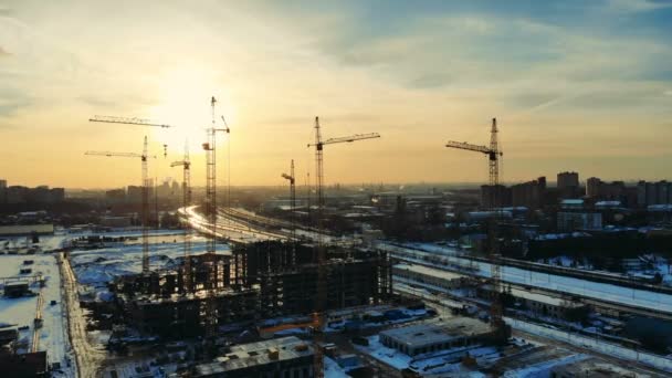 Une maison bâtie sur un chantier enneigé avec grues . — Video