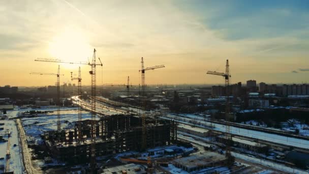 Un chantier de construction avec des grues dans une ville proche de la route . — Video