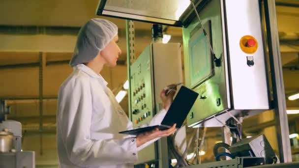 Kadın işçi gıda üretimi bir fabrikada kontrol etmek için dizüstü bilgisayar kullanarak. — Stok video