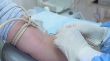Doktor iğne kan, almak için hasta kolundan Merkezi bağış koyar.