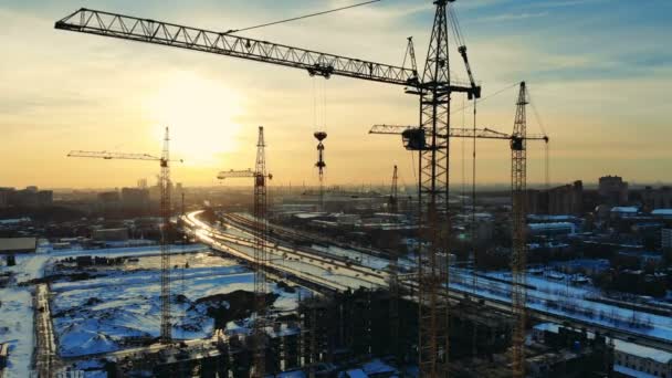 Byggarbetsplats med arbetar tornkranar på sunset bakgrund. — Stockvideo