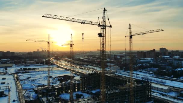 Beaucoup de grues métalliques sur un site, la construction d'une maison à plusieurs étages . — Video