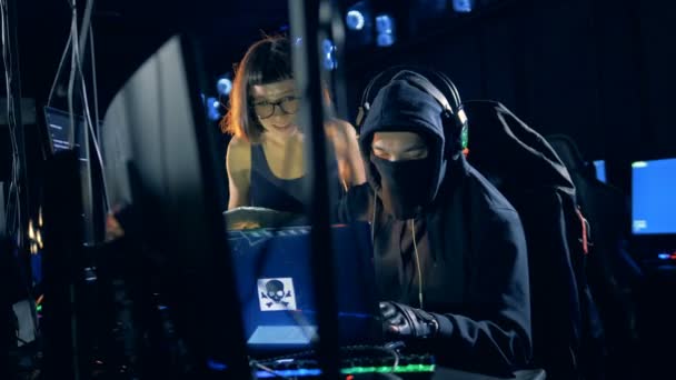 Zwei gut gelaunte Hacker bei der Arbeit in ihrem Versteck — Stockvideo