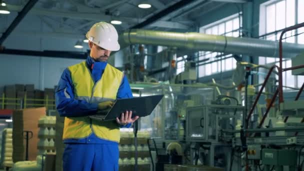 Unidade de produção de produtos químicos com um trabalhador do sexo masculino operando um laptop — Vídeo de Stock