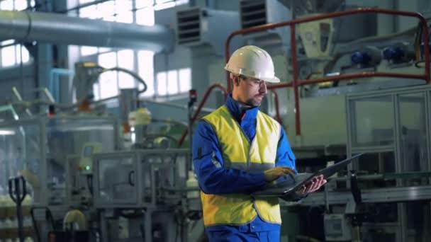 Spécialiste masculin observe le processus de production dans les locaux de l'usine . — Video