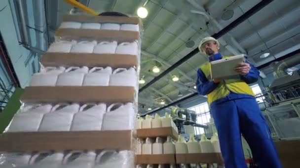 Plastic containers are getting wrapped up under control of a male inspector — Stock Video