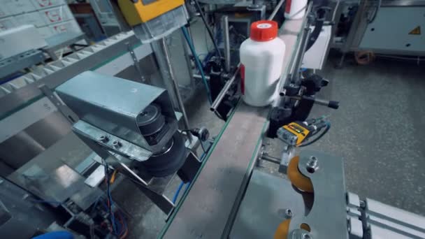 Bouteilles en plastique avec des produits chimiques sont polis par une machine — Video