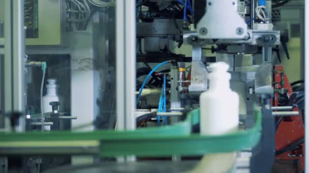 Bodems van witte plastic flessen worden steeds gesneden door het mechanisme — Stockvideo