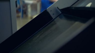 Bir parça işleyen endüstriyel makine yanında duran bir erkek işçi