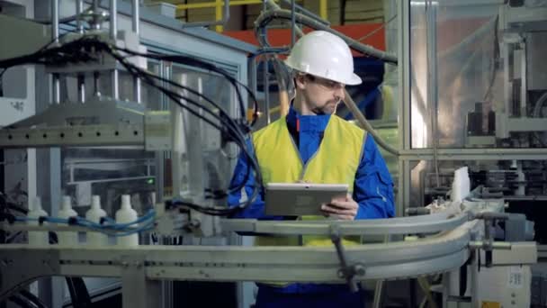 Engenheiro masculino está inspecionando a produção de recipientes de plástico — Vídeo de Stock