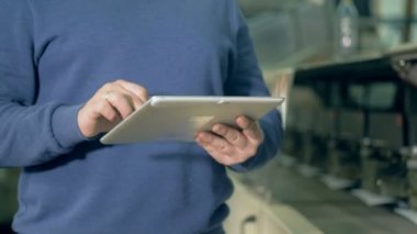 Bir tablet bir yazdırma ofisinde bir adam türlerinde yakın çekim.