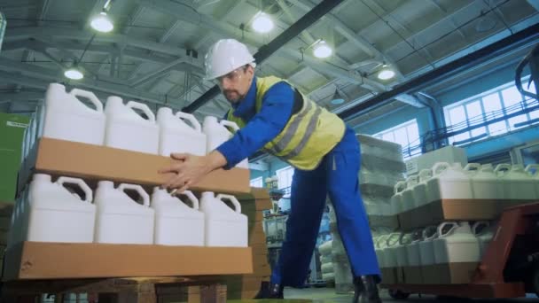 Trabalhador industrial está empilhando bandejas de papelão com caixas de plástico — Vídeo de Stock