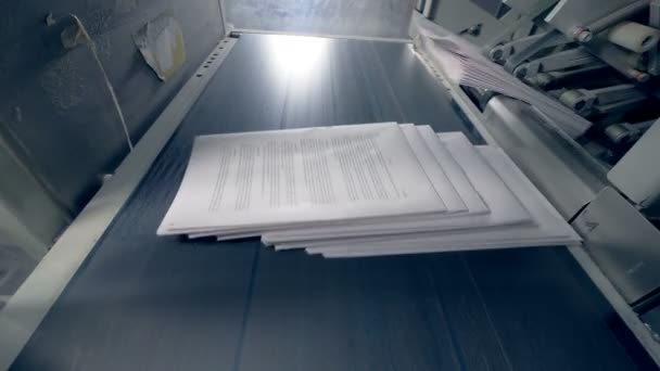 Stapels papier krijgen op een transportband, close-up. — Stockvideo