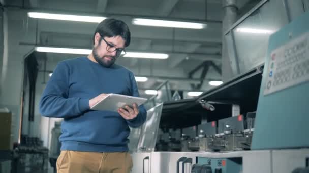 Инженер проверяет работу типографского оборудования, крупным планом . — стоковое видео