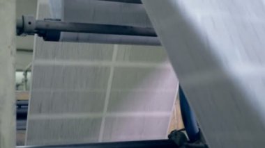 Büyük gazete sayfası rollling bir konveyör üzerine yakın çekim.