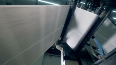 Basılı gazete çalışırken konveyör üzerinde alt görünümü hareket.