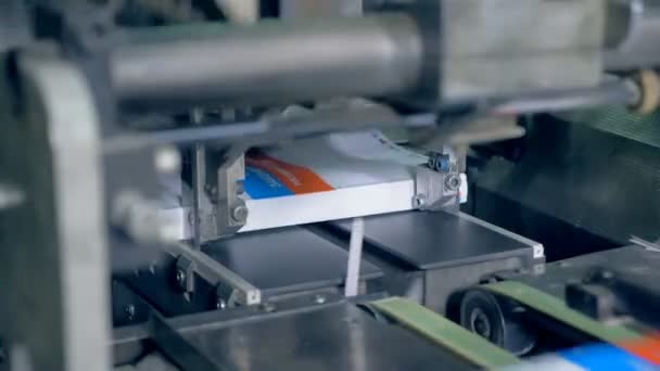 Printing equipment works with books on a conveyor, close up. — Stock Video