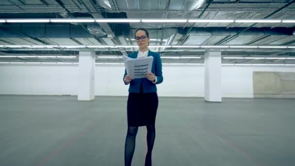 Une femme jette des papiers et commence à danser dans une salle de bureau . — Video