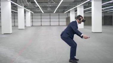 Bir ofiste Vr kulaklık giyen bir işadamı atlar.