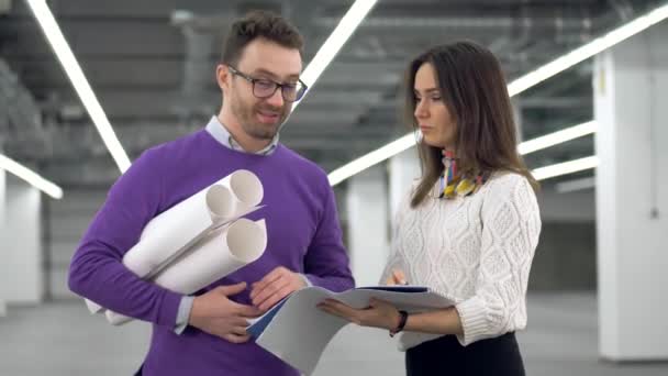 Two engineers talk and hold documents, discussing a project. — Stock Video