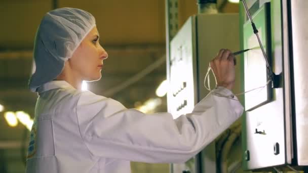 Lady em roupas de trabalho está navegando em uma tela sensível ao toque de fábrica — Vídeo de Stock