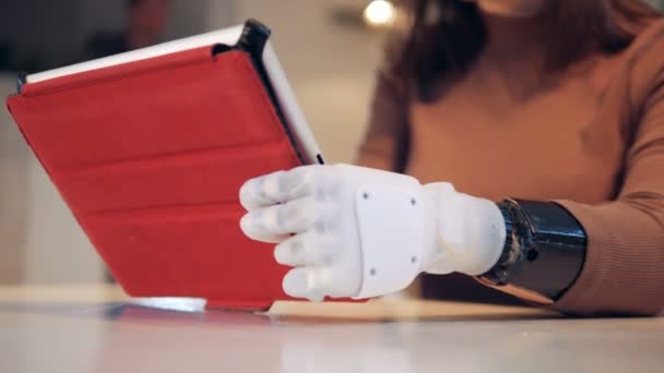 Mujer con la mano protésica utiliza una tableta, de cerca . — Vídeos de Stock