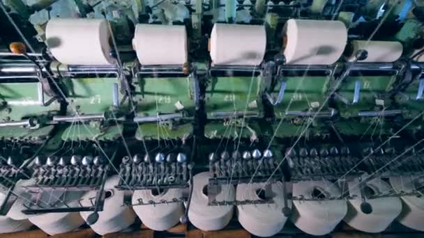 Pinzas de coser con hilos blancos girando en máquinas textiles de fábrica . — Vídeos de Stock