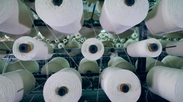 Carretes grandes con hilo blanco girando mientras las máquinas textiles de fábrica trabajan . — Vídeos de Stock