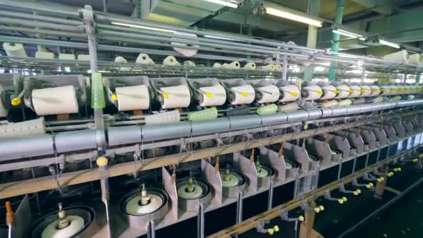 Draaiende machines werken in textielfabriek, spoolen draad op clews. — Stockvideo