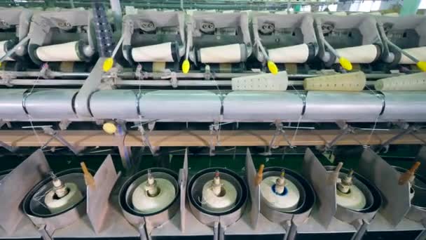 Modern mechanism spools yarn on white clews at a factory. — Stock Video