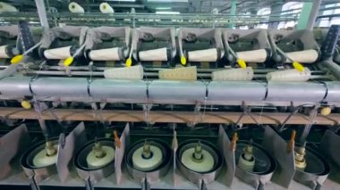 Modern Tekstil Fabrikası makineleri beyaz konu ve makaralar ile çalışma.