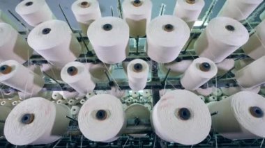 Bir tekstil fabrikası'nda bir raf üzerinde dönen fiber ile büyük clews.