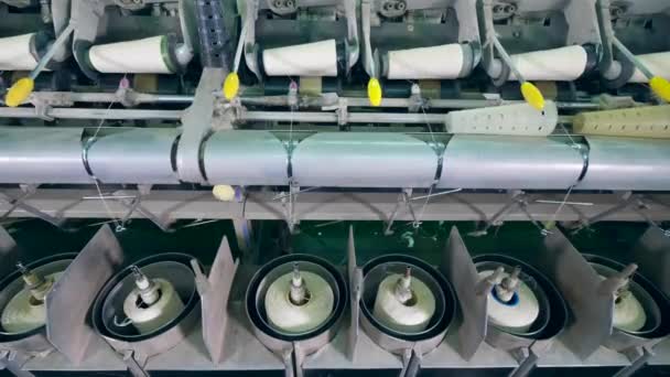 Textile factory equipment coils white fiber onto spools automatically. — Stock Video