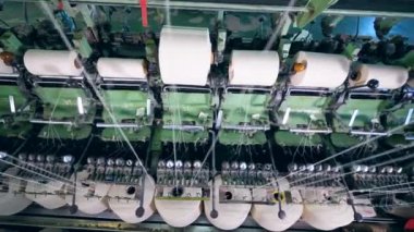 Beyaz fiber bir tekstil fabrikasında büyük makaralar üzerinde açma.