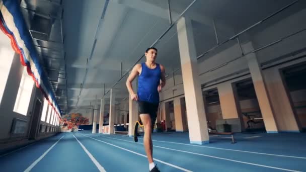 Um homem com perna artificial correndo em uma pista, prótese moderna . — Vídeo de Stock