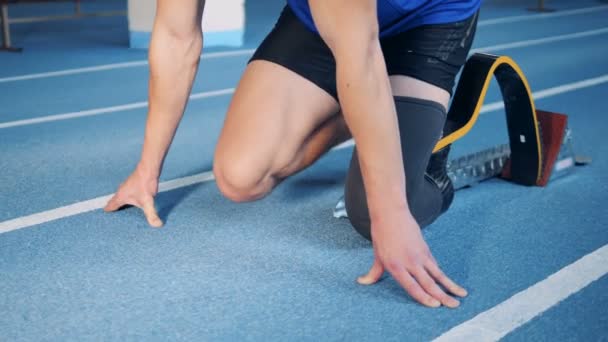 Une personne avec une jambe artificielle commence à courir sur une piste, une prothèse bionique . — Video