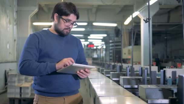 Afdrukken van huis werknemer staat naast industriële machines — Stockvideo