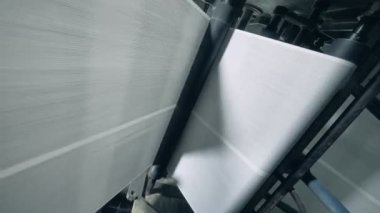 Uzun beyaz web kağıt tek başına çalışırken makine hareket ediyor