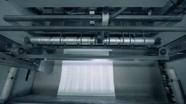 Papír oldalak-val szöveg egyre bocsátja ki a gyári mechanizmus egy felülnézet — Stock videók
