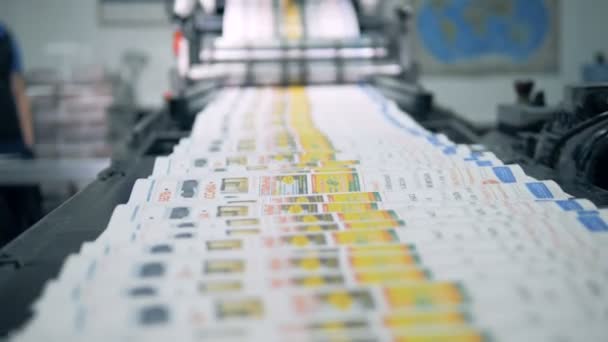 Цветные печатные журналы движутся вдоль конвейерной ленты — стоковое видео