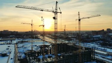 Günbatımı inşaat alanında uzun boylu Vinçler